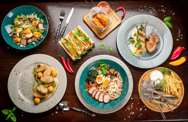 istock Different colorful meals on dark wooden table in the restaurant. 1420810537