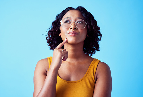 Thinking, idea brainstorming and young woman with a curious mind looking for inspiration. Portrait of a female with glasses with a new strategy innovation, motivation and goal mindset and vision