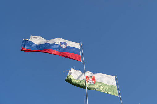 Picture of Liubliana and Slovenia fabric flags waving in the blue sky