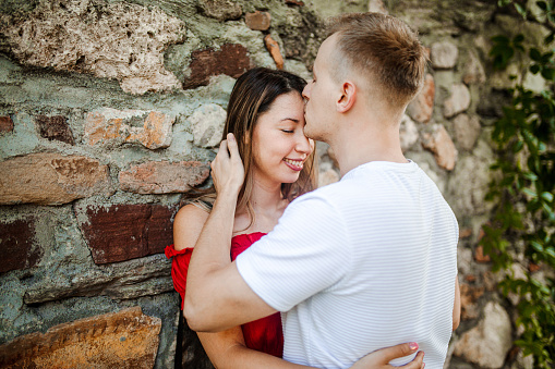 Young couple in love hugging and kissing in the park