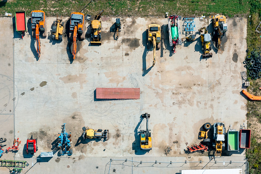 Parking lot with construction machinery, excavators and bulldozers, top view
