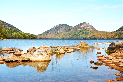 The North and South Bubble Mountains are seen at an autumn sunset from the shoreline of Jordan Pond in Acadia National Park on Mount Desert Island, Maine.