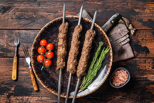 Grilled Shish kebab on skewers from minced lamb beef meat, Lula kebab. Wooden background. Top view.