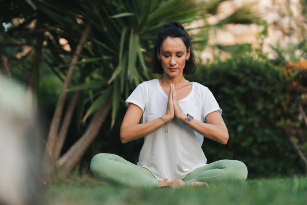 istock Young woman practicing yoga in park 1420835951