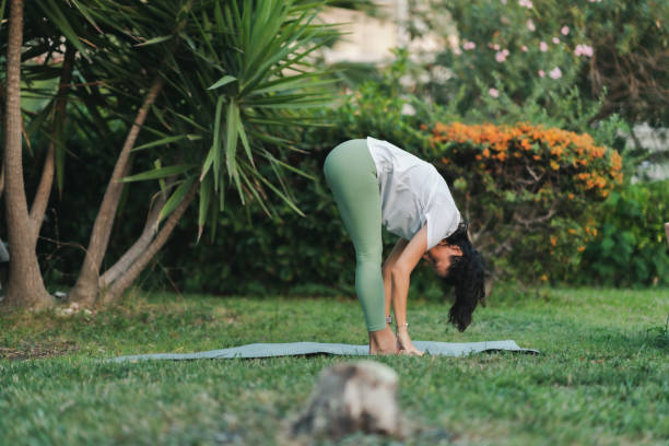 istock Young woman practicing yoga in park 1420836462