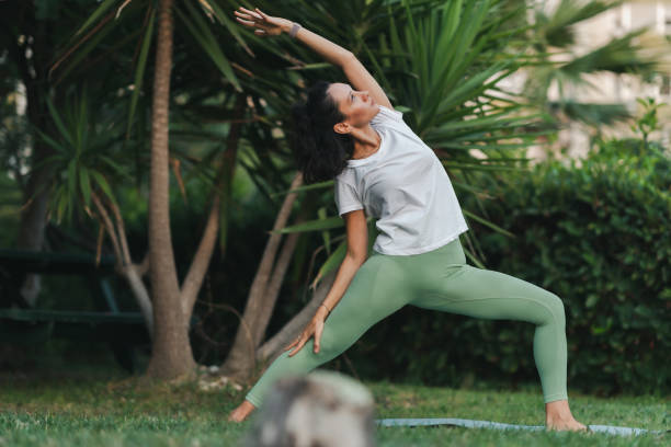 istock Young woman practicing yoga in park 1420837321