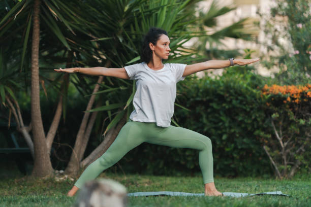 Young woman practicing yoga in park stock photo