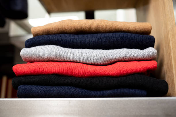 istock Stack of colorful sweaters on store shelf 1420837917