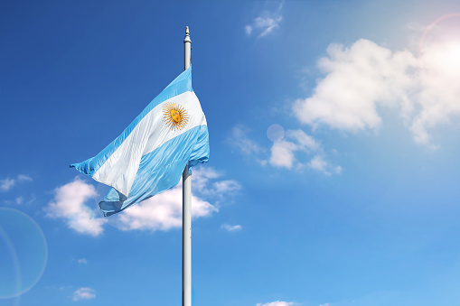 Argentinian flag waving over a blue sky with copy space.