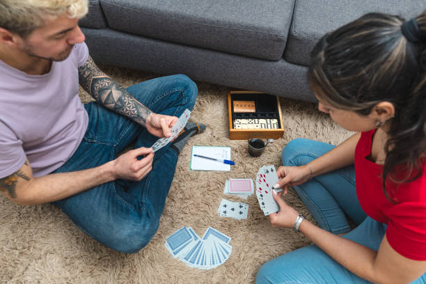 due persone che giocano a ramino a casa, un classico gioco di carte - rummy foto e immagini stock