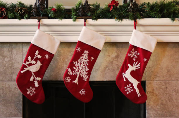 Three red christmas stockings on fireplace mantle Three red christmas stockings hanging on fireplace mantle nylon stock pictures, royalty-free photos & images
