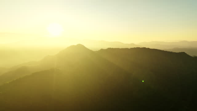 Drone flight on the hill at sunrise, hopeful, warm, shot by 4k ProRes Drone
