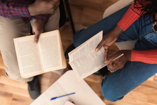 istock Unrecognizable man and woman analyzing the novel while reading at the library 1420850715
