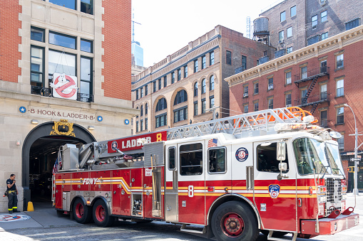New York City, NY, USA - August 20, 2022: The firefighter is backing up the firetruck into the Hook and Ladder Company 8 fire station in New York City, NY, USA, a popular tourist attraction.