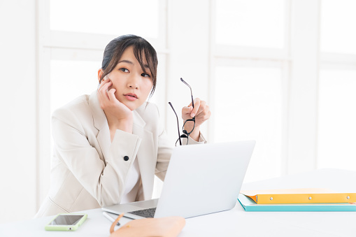 Beautiful young asian businesswoman using laptop,think