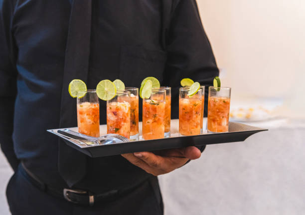 istock Unrecognizable waiter dressed in black with a tray with shrimp cocktail sandwiches 1420865100