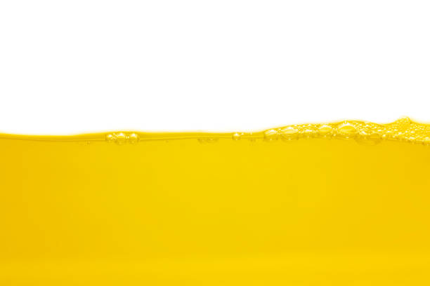 istock Surface bubbles and ripple on yellow and gold liquid set against a white background. 1420865268