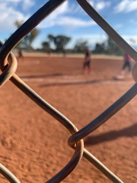 istock Softball players through fence 1420870786