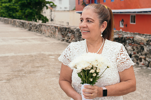 Portrait of mature bride with a bouquet of flowers on the street