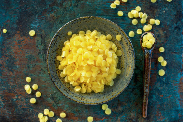 istock yellow beeswax pellets in  green grunge ceramic plate. 1420873684