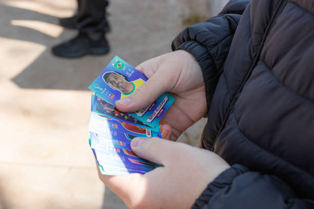 genitori e figli appassionati di calcio si scambiano le figurine dell'album panini - piazza delle vettovaglie foto e immagini stock