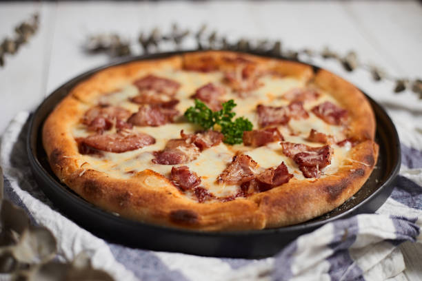 Homemade bacon and cheese pizza on the table.