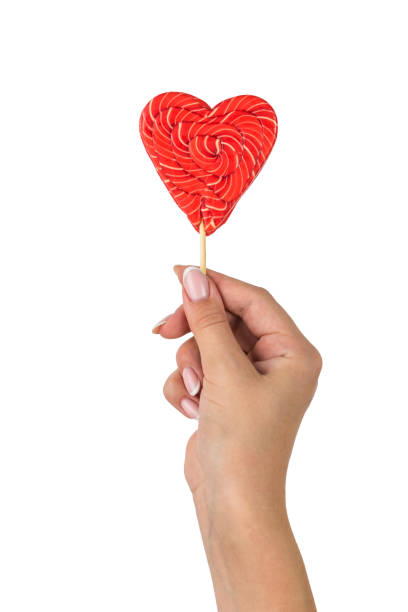 istock A woman's hand with a beautiful heart-shaped candy isolated on a white background. 1420878566