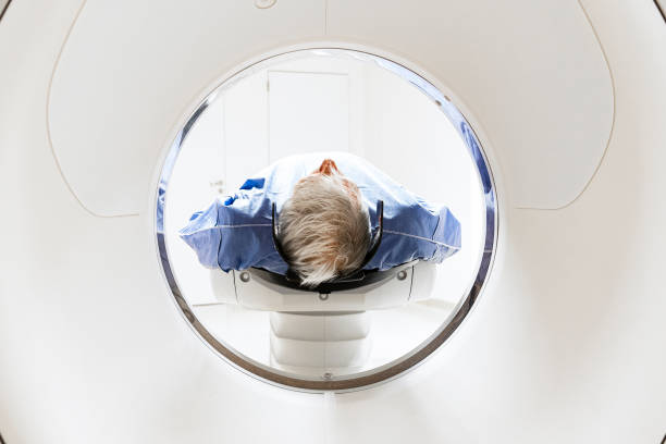 Male patient going through MRI scan machine tunnel stock photo