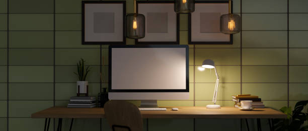 istock Modern home office workplace at night with low light from table lamp, desktop computer mockup 1420883078
