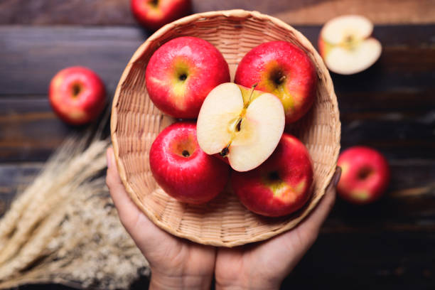 istock Red apple fruit in basket holding by hand 1420883460