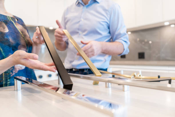 istock Female and male designers holding kitchen cabinet pulls for colour selection, making a decision for home interior design and decor in a new kitchen in a new home. 1420885105