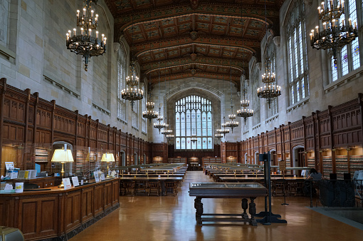 The Expansive Room of the Boston Public Library with all the tables, chairs and green table lamps.