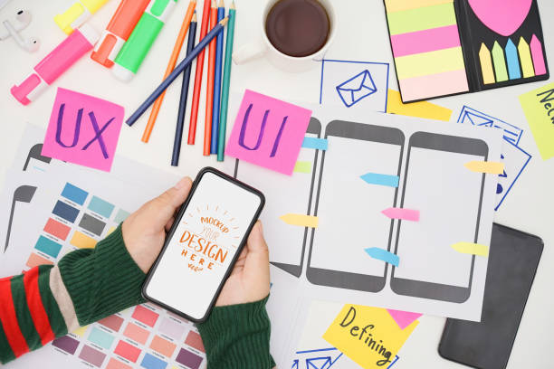 istock Creative top view photo of UX UI designer working space with mobile white screen mockup, white screen for graphic montage. 1420892704