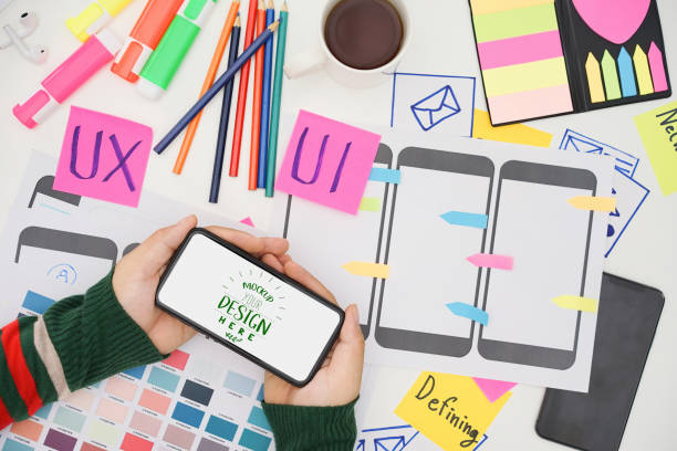 istock Creative top view photo of UX UI designer working space with mobile white screen mockup, white screen for graphic montage. 1420892707