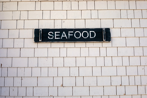 Seafood signs on a wooden-tiled wall