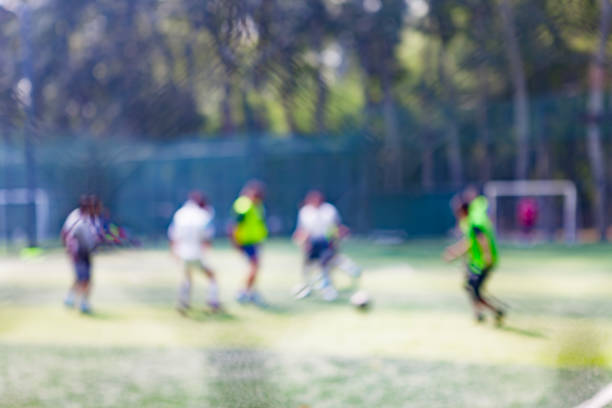 les gens frappent le ballon sur le terrain de football dans le parc, déconcentrés - american football football focus on foreground team sport photos et images de collection