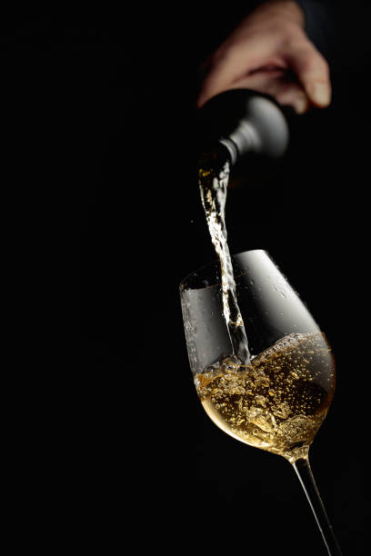 istock Pouring white wine in a glass goblet. 1420899234