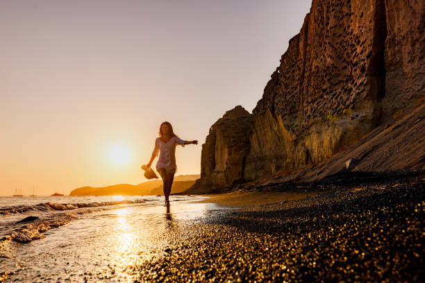 istock Happy woman having fun on the beach at sunset. 1420903555