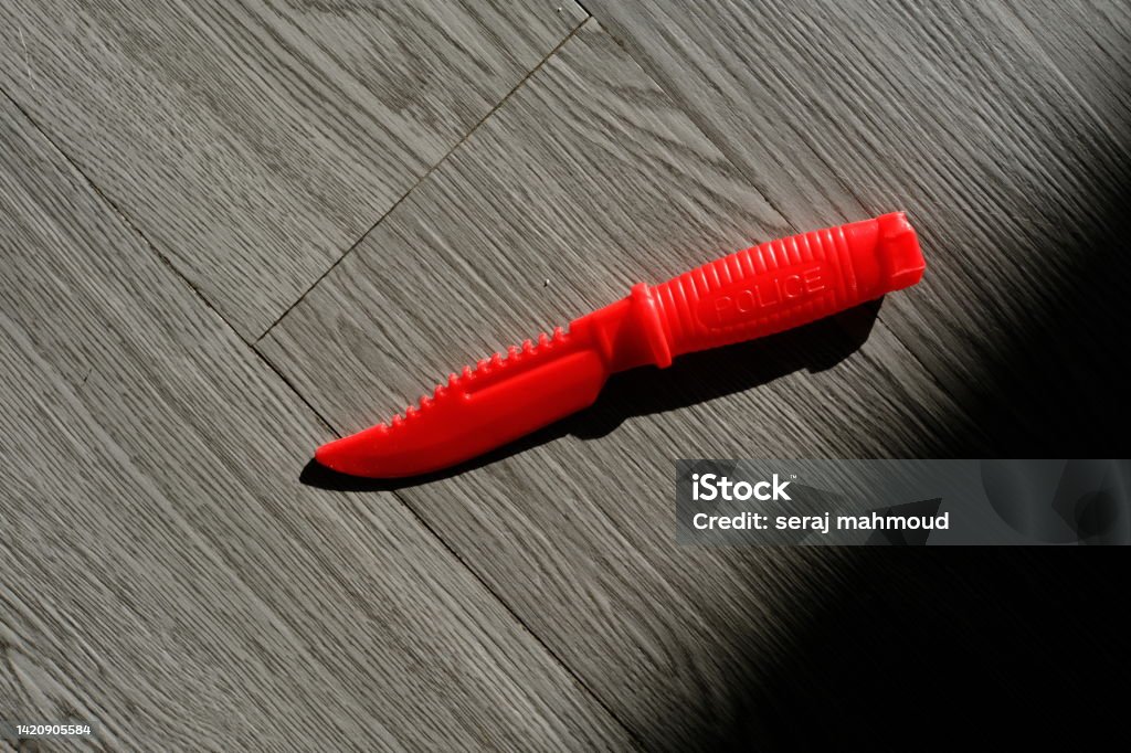 knife toy with the shadow on the wooden floor Black Color Stock Photo