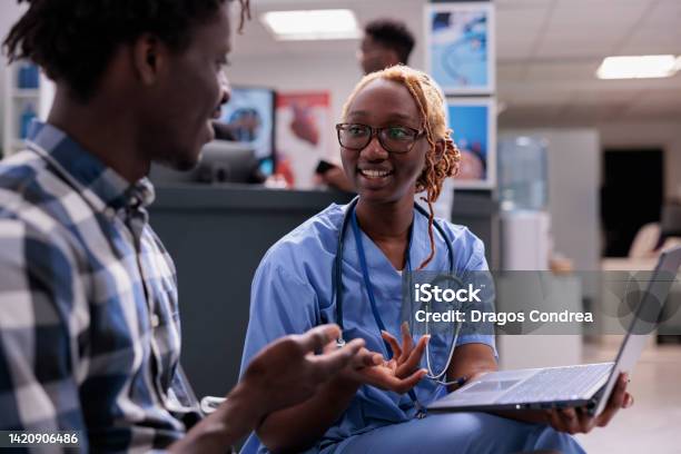 Woman Nurse Consulting Patient At Clinic Stock Photo - Download Image Now - Healthcare And Medicine, Assistant, Medical Exam