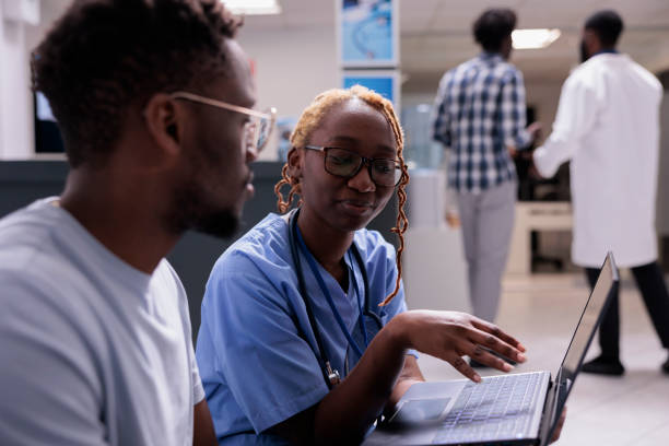 istock Female nurse using laptop with patient 1420906497