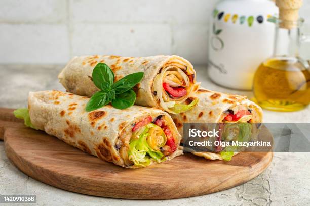 Wraps With A Soft Flatbread Rolled Around A Filling With Vegetables And Cheese Tomato Fried Eggplant Lettuce Vegetarian Food Concept Light Background Stock Photo - Download Image Now