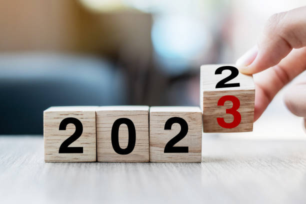 hand-flipping-block 2022 bis 2023 text in der tabelle. vorsatz, strategie, plan, ziel, motivation, neustart, business und neujahrsurlaubskonzepte - aiming challenge business throwing stock-fotos und bilder