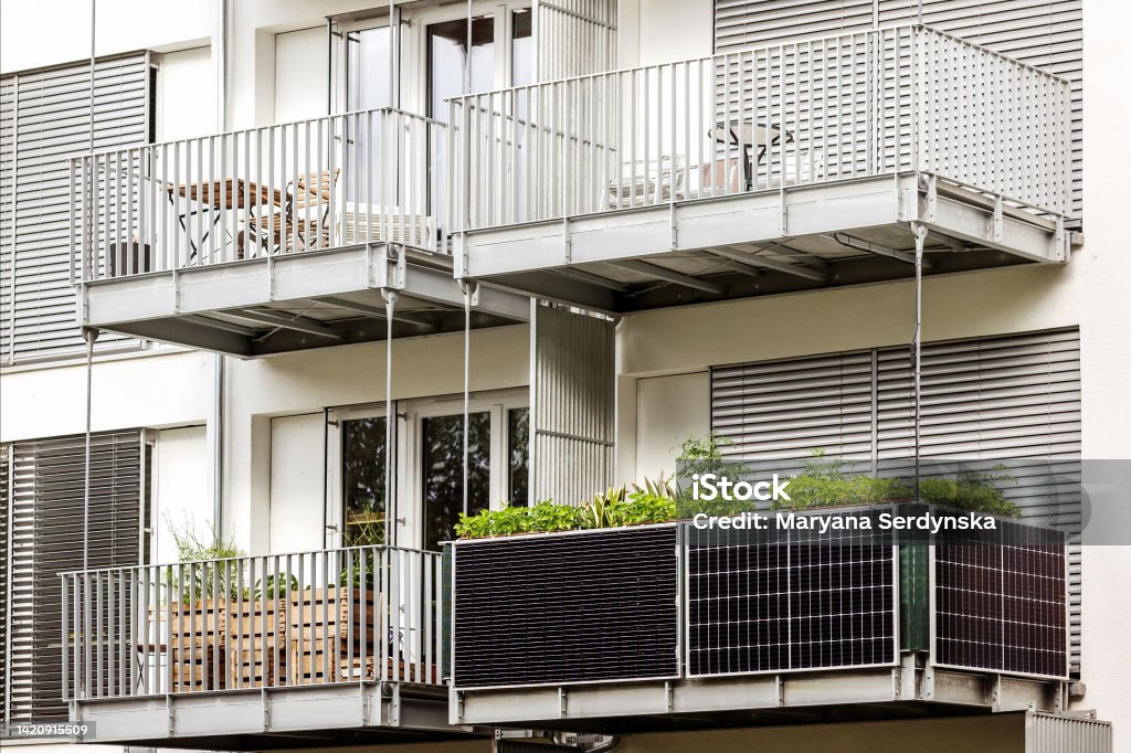 Solar panels on Balcony of  Apartment Building Solar panels on Balcony of  Apartment Building. Growing greenery in  modern multi-story building Balcony Stock Photo