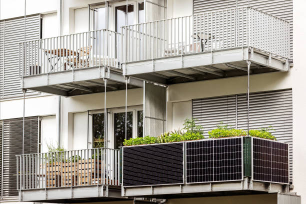 Solar panels on Balcony of  Apartment Building Solar panels on Balcony of  Apartment Building. Growing greenery in  modern multi-story building power station stock pictures, royalty-free photos & images