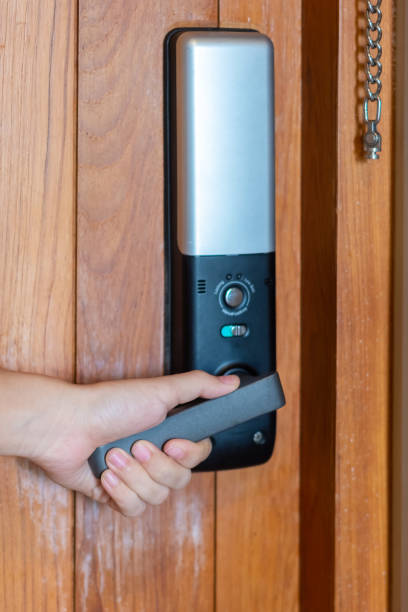 istock man holding handle of smart digital door lock while open or close the door. Technology, electrical and lifestyle concepts 1420916642