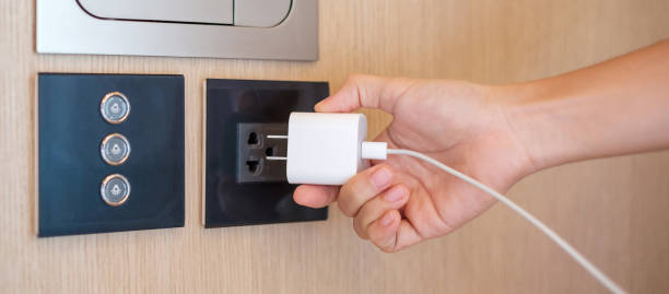 nahaufnahme finger abstecken oder stecken des stromgeräts zu hause. energiespar-, strom-, elektro- und lifestyle-konzepte - electric plug outlet human hand electricity stock-fotos und bilder