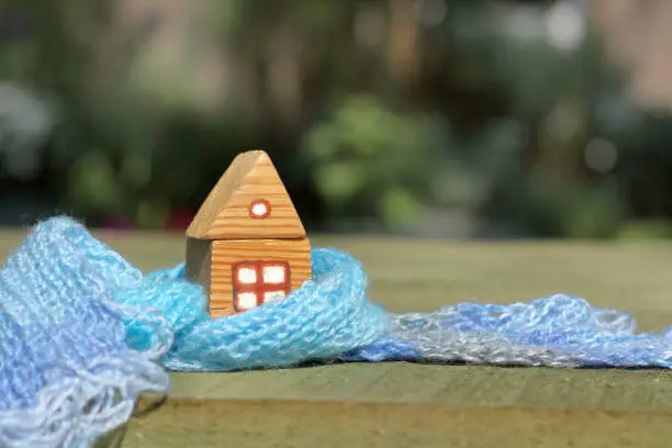 small wooden house is wrapped in a large blue scarf
