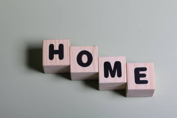 istock Home word on wooden block  on green background 1420917981
