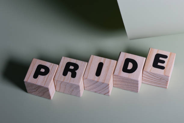 istock PRIDE word on wooden block  on green background 1420918917